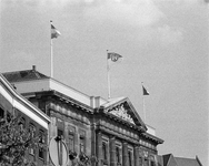 855218 Gezicht op de bovengevel van het Stadhuis (Stadhuisbrug 1), waar de vlaggen van Utrecht en Hannover wapperen, ...